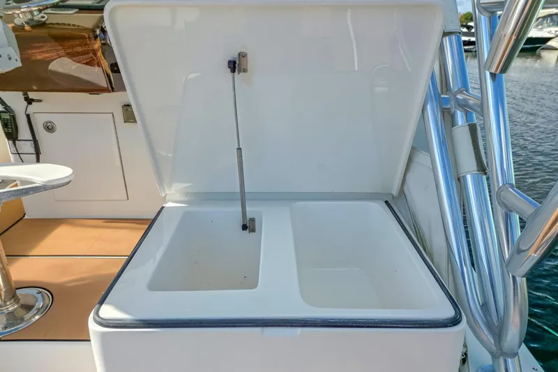  Yacht Photos Pics Open storage compartment on 2005 Buddy Davis 35' Express boat, docked by the water.