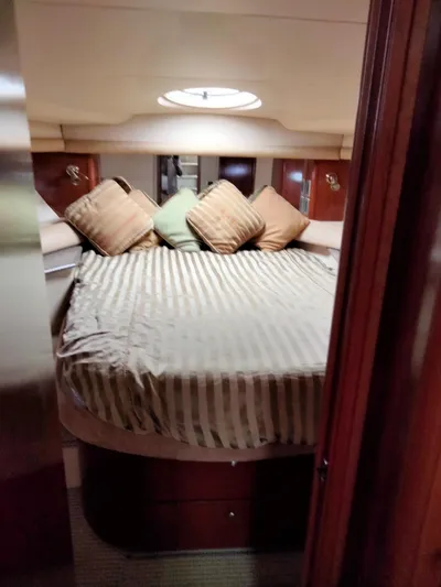 Sunshine Yacht Photos Pics Interior of 2005 Meridian 459 Motoryacht bedroom with striped bedding and pillows.