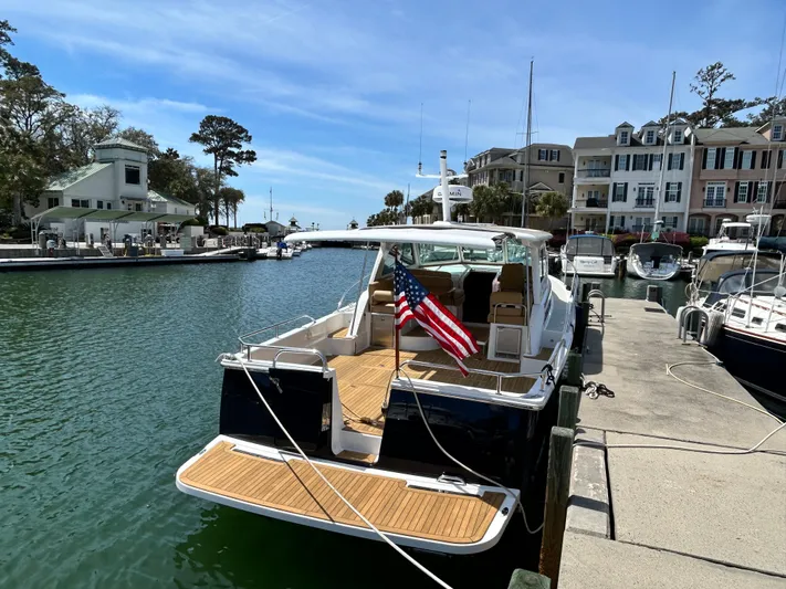  Yacht Photos Pics 2014 Back Cove Downeast 37 docked in a scenic marina with American flag.