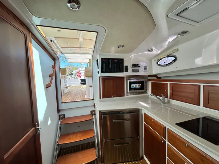  Yacht Photos Pics Luxurious interior of 2014 Back Cove Downeast 37 yacht, featuring modern kitchen and wooden cabinetry.