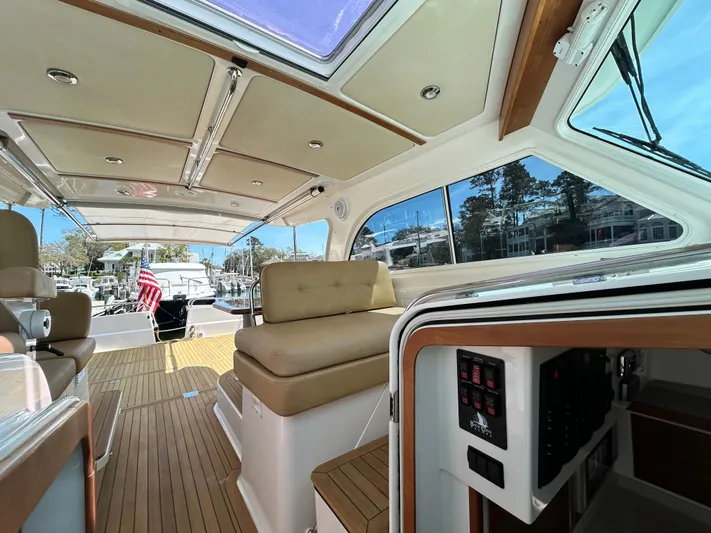  Yacht Photos Pics 2014 Back Cove Downeast 37 yacht interior with seating and control panel, featuring wood accents.