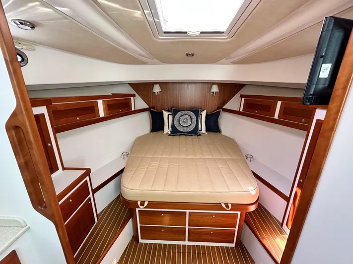  Yacht Photos Pics Luxurious cabin interior of 2014 Back Cove Downeast 37 with wood accents and cozy bedding.