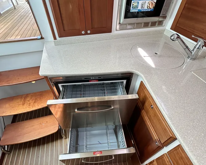  Yacht Photos Pics 2014 Back Cove Downeast 37 yacht kitchen with open stainless steel drawer and wooden cabinetry.