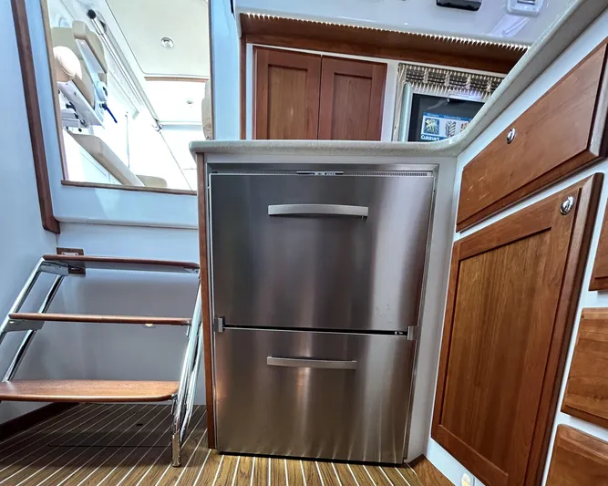  Yacht Photos Pics 2014 Back Cove Downeast 37 interior with stainless steel fridge and wooden cabinetry.