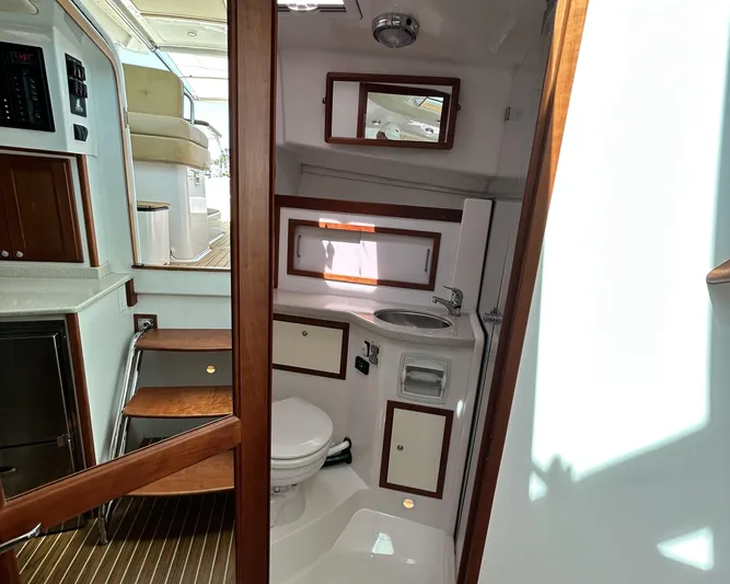  Yacht Photos Pics 2014 Back Cove Downeast 37 yacht interior with compact bathroom and wooden accents.