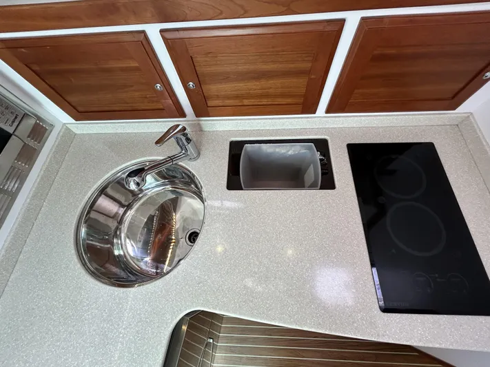  Yacht Photos Pics 2014 Back Cove Downeast 37 yacht kitchen with sink, stove, and wooden cabinets.