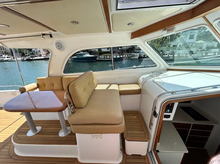  Yacht Photos Pics 2014 Back Cove Downeast 37 interior with seating and table, overlooking marina.