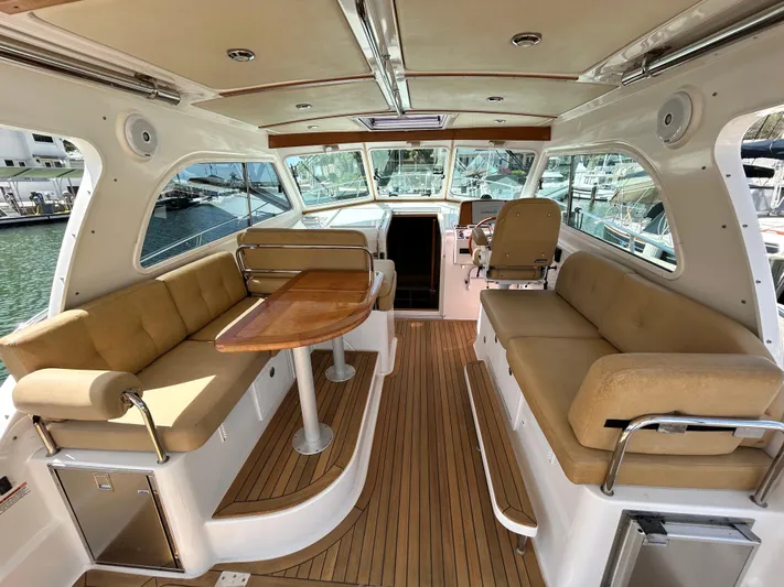  Yacht Photos Pics Interior of 2014 Back Cove Downeast 37 boat with beige seating and wooden table.