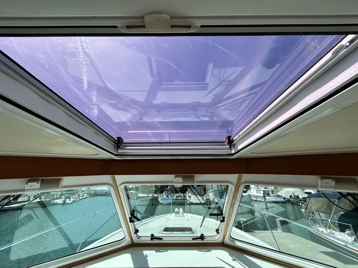  Yacht Photos Pics Interior view of 2014 Back Cove Downeast 37 boat with open sunroof and marina in background.