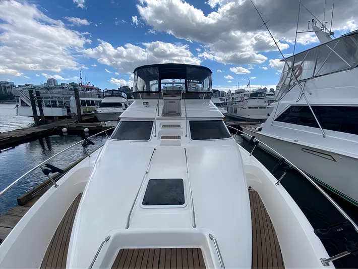  Yacht Photos Pics 2000 Sea Ray 450 Express Bridge yacht docked at marina under cloudy sky.