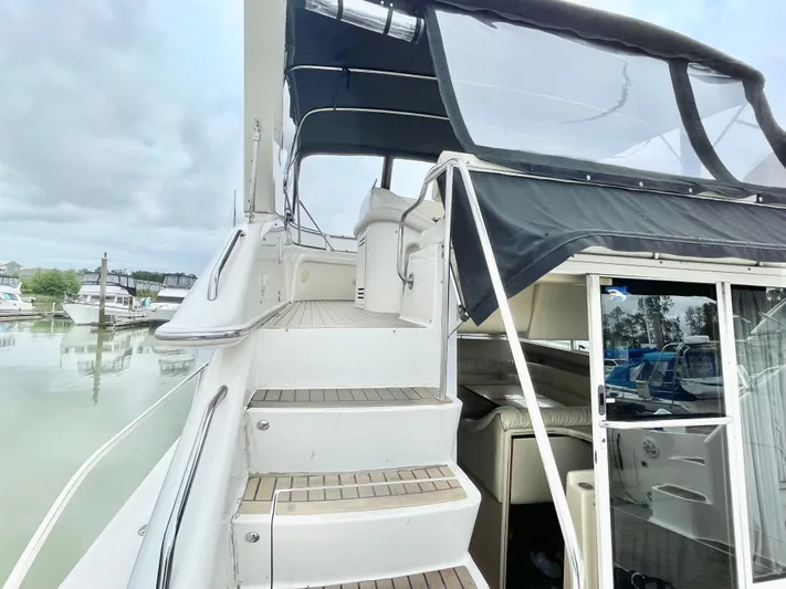  Yacht Photos Pics 2000 Sea Ray 450 Express Bridge yacht with stairs and covered seating area.