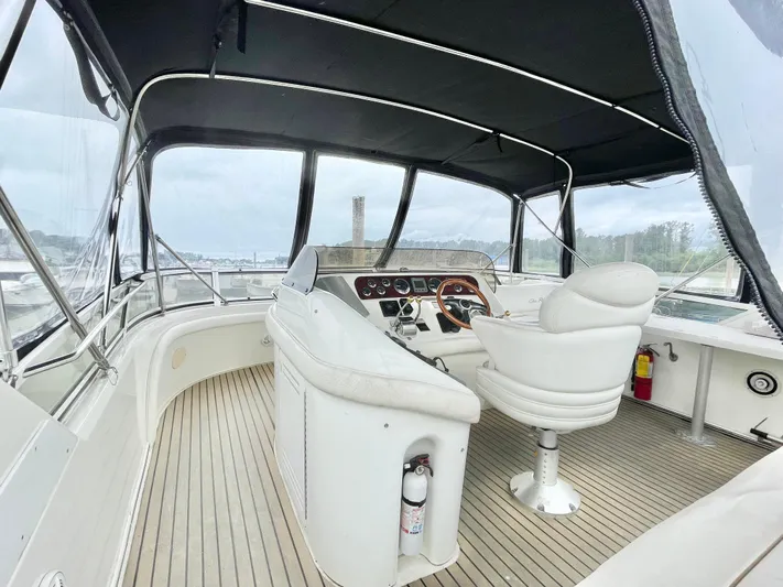  Yacht Photos Pics 2000 Sea Ray 450 Express Bridge helm with seating, covered deck, and panoramic views.