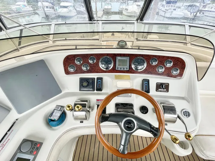 Yacht Photos Pics Cockpit of 2000 Sea Ray 450 Express Bridge with wooden steering wheel and control panel.