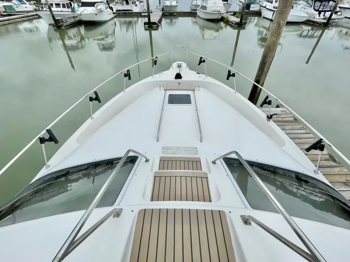  Yacht Photos Pics Bow view of 2000 Sea Ray 450 Express Bridge docked in a marina.