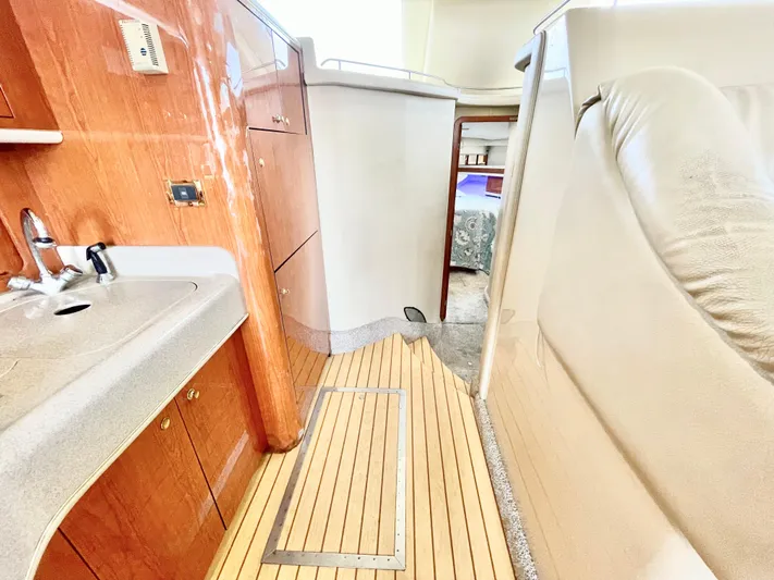  Yacht Photos Pics Interior of 2000 Sea Ray 450 Express Bridge with wood flooring and compact kitchen area.