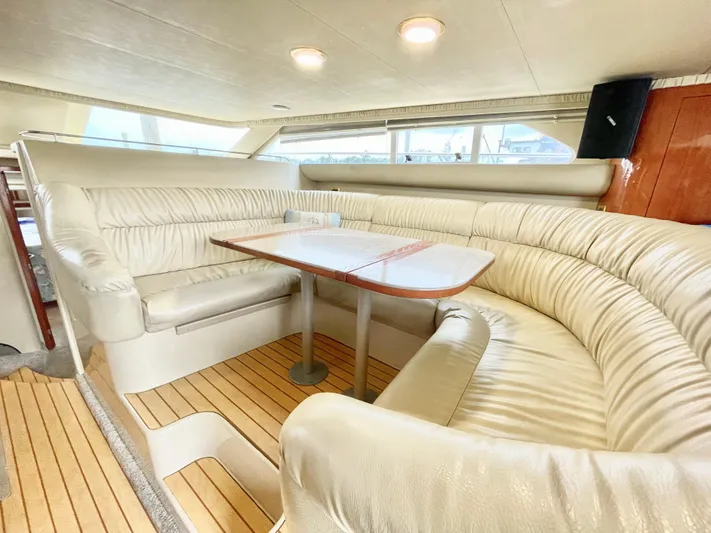  Yacht Photos Pics Luxurious interior of 2000 Sea Ray 450 Express Bridge with plush seating and wooden table.
