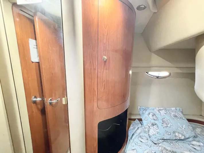  Yacht Photos Pics Interior cabin of 2000 Sea Ray 450 Express Bridge with wood paneling and bedding.