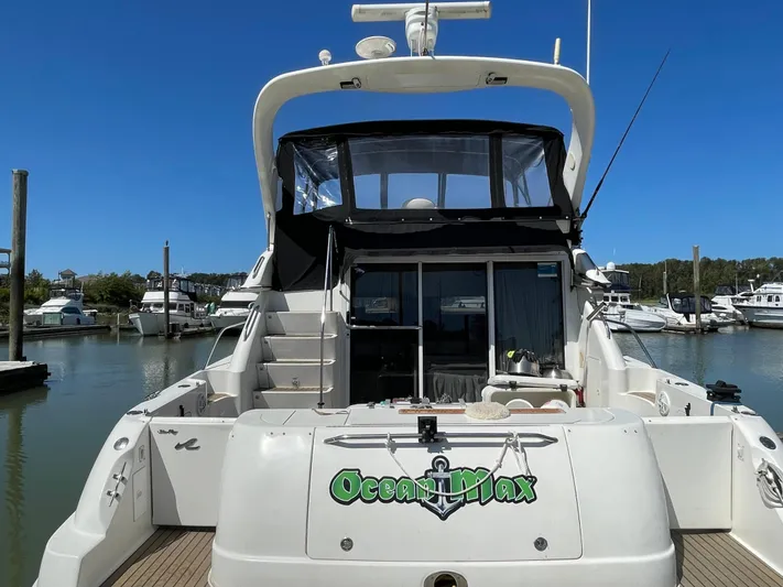  Yacht Photos Pics 2000 Sea Ray 450 Express Bridge yacht docked at marina, rear view with stairs and canopy.