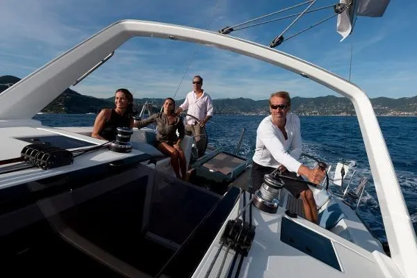 Secret Location Yacht Photos Pics Four people sailing on a 2014 Beneteau Oceanis 45 yacht in open waters.