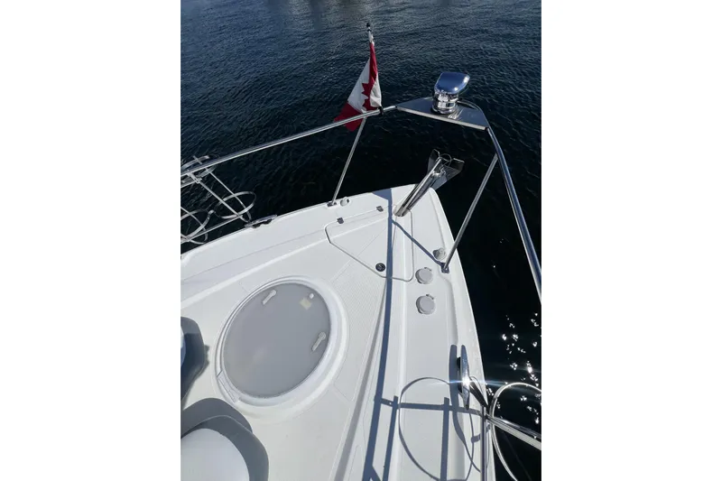  Yacht Photos Pics 2010 Cruisers Yachts 360 Express bow with Canadian flag on calm water.