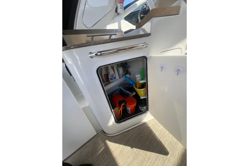  Yacht Photos Pics Open storage compartment on 2010 Cruisers Yachts 360 Express, containing various cleaning supplies.
