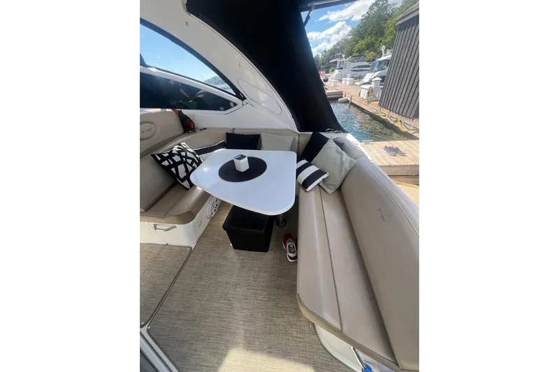  Yacht Photos Pics 2010 Cruisers Yachts 360 Express interior with seating, table, and cushions by the dock.