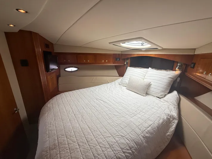  Yacht Photos Pics Luxurious bedroom in 2004 Cruisers Yachts 455 Express Motor Yacht, featuring elegant wood finishes.