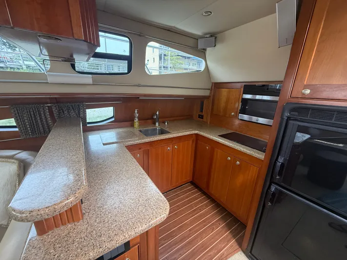  Yacht Photos Pics Luxurious 2004 Cruisers Yachts 455 Express Motor Yacht kitchen with wood cabinetry and modern appliances.