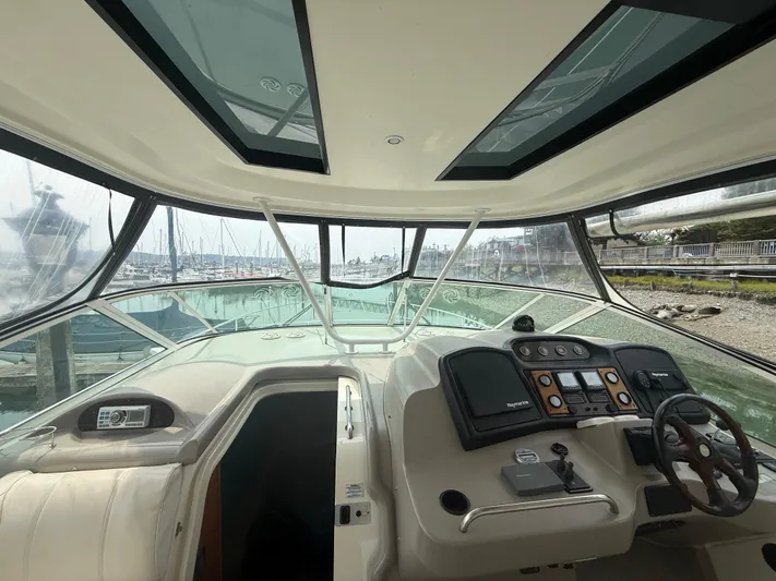  Yacht Photos Pics Interior view of 2004 Cruisers Yachts 455 Express Motor Yacht helm with marina background.