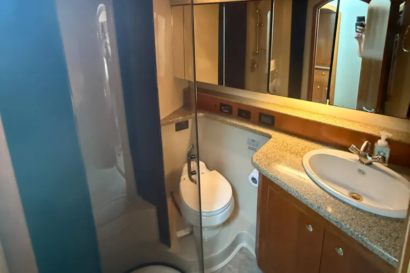  Yacht Photos Pics 2004 Cruisers Yachts 455 Express Motor Yacht bathroom with sink, toilet, and mirror.