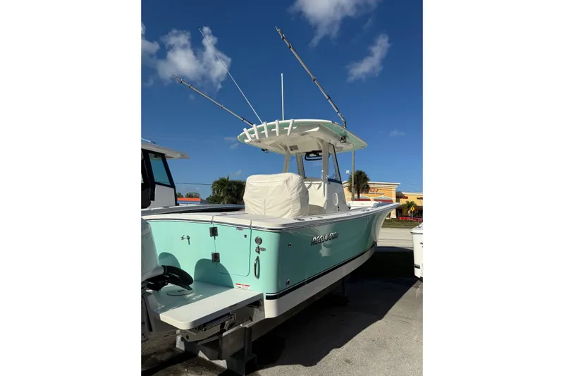 28-563 Brokerage Higgins Yacht Photos Pics 2021 Regulator 28 boat with fishing rods, light blue hull, and T-top under clear sky.