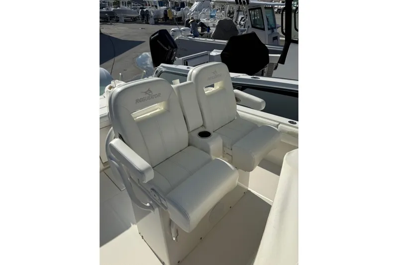 28-563 Brokerage Higgins Yacht Photos Pics 2021 Regulator 28 boat with white cushioned seats and armrests.