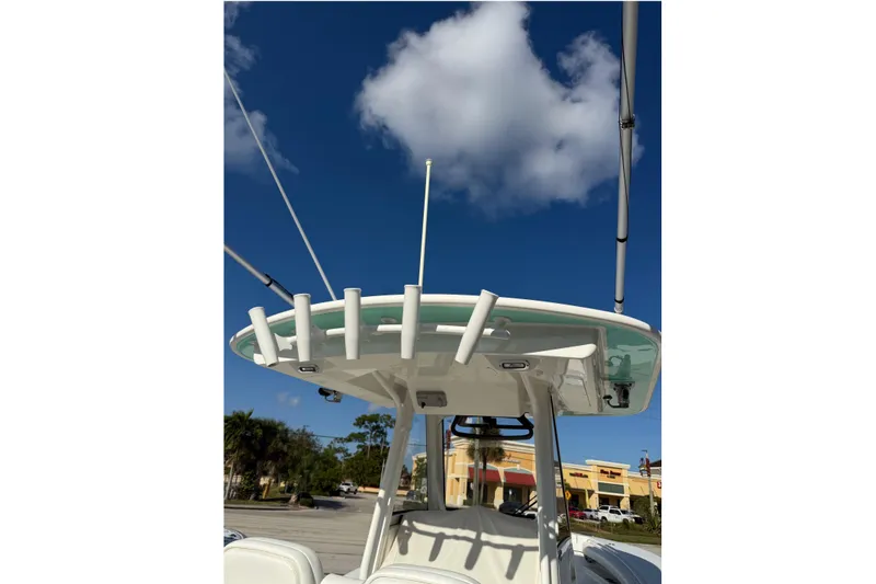 28-563 Brokerage Higgins Yacht Photos Pics 2021 Regulator 28 boat with T-top and rod holders under a clear blue sky.