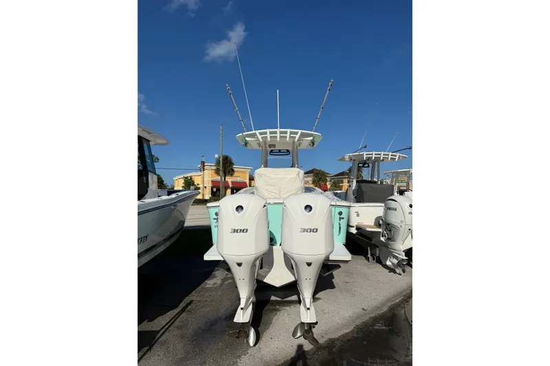 28-563 Brokerage Higgins Yacht Photos Pics 2021 Regulator 28 boat with twin 300 horsepower engines, docked under clear blue sky.