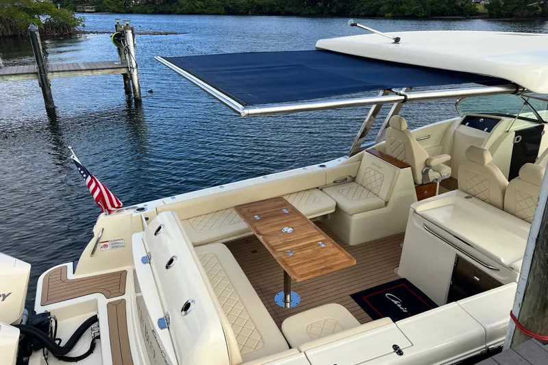 Yacht Photos Pics 2023 Chris-Craft Calypso 30 boat with elegant seating and wooden table on calm water.
