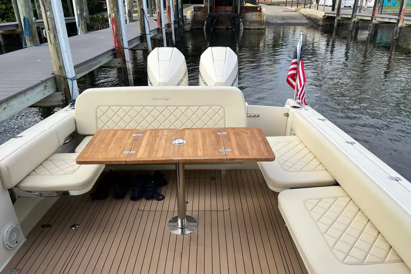  Yacht Photos Pics 2023 Chris-Craft Calypso 30 boat interior with seating, table, and American flag.