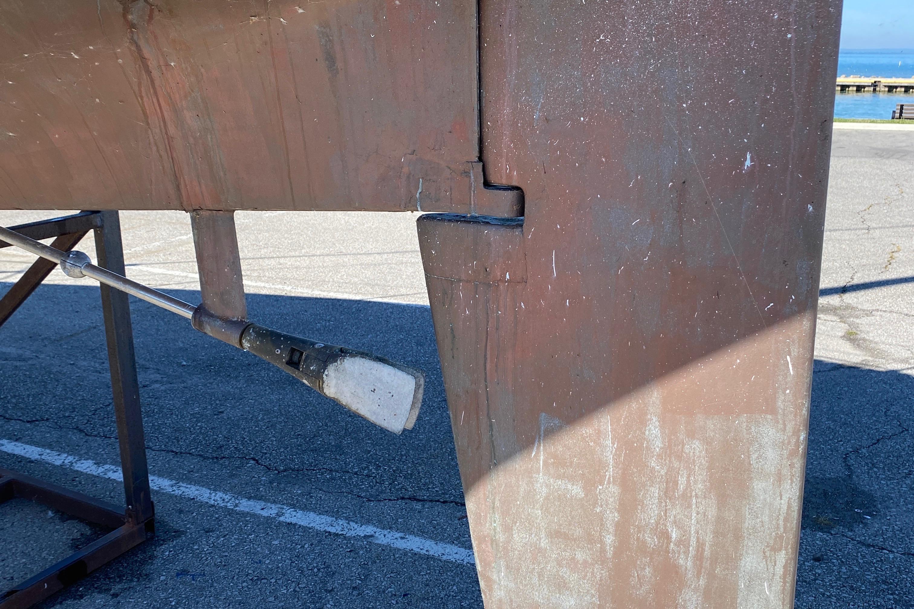 1985 CS 33 Sloop keel detail in dry dock, showing rudder and hull structure.