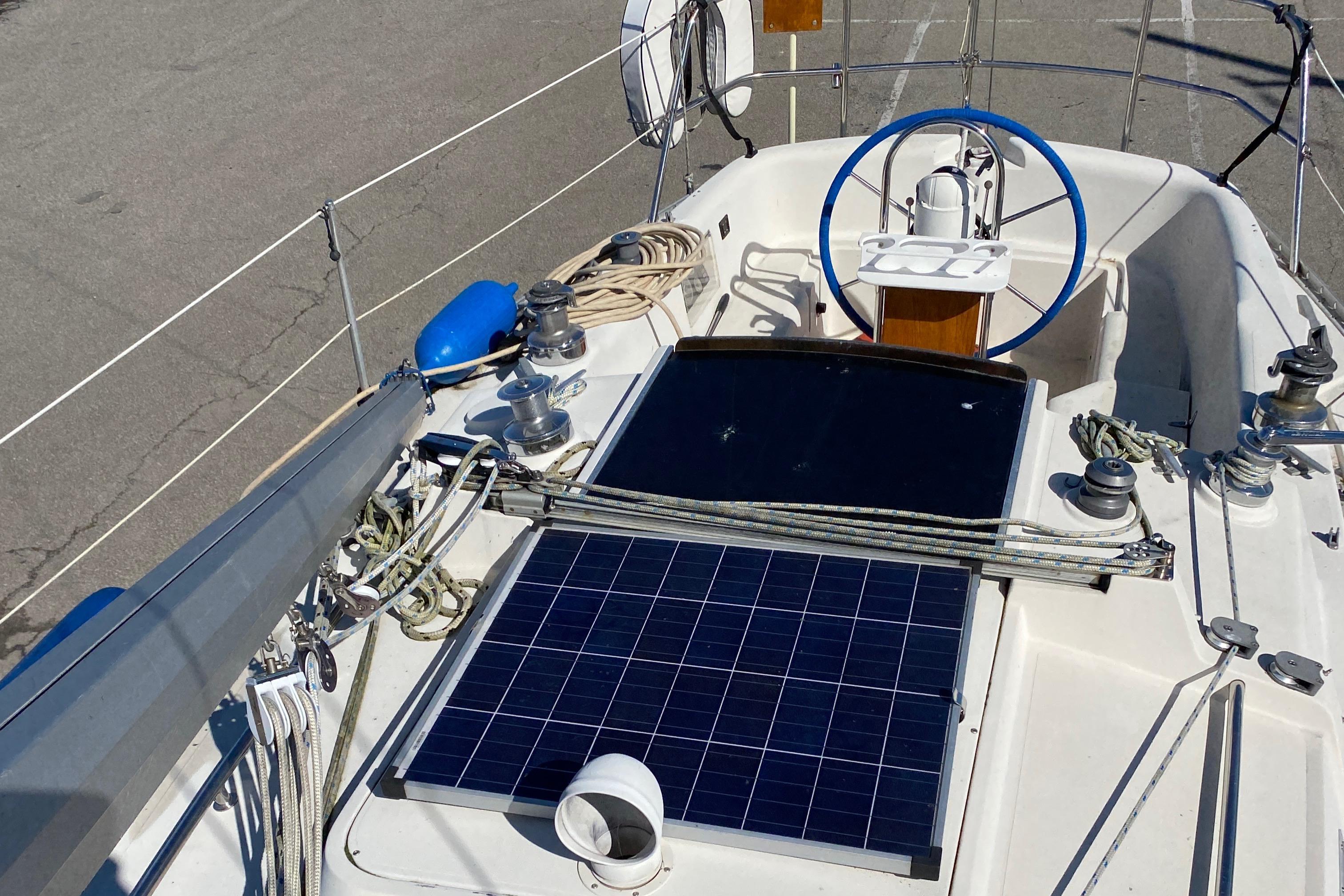 1985 CS 33 Sloop sailboat deck with solar panel and steering wheel.