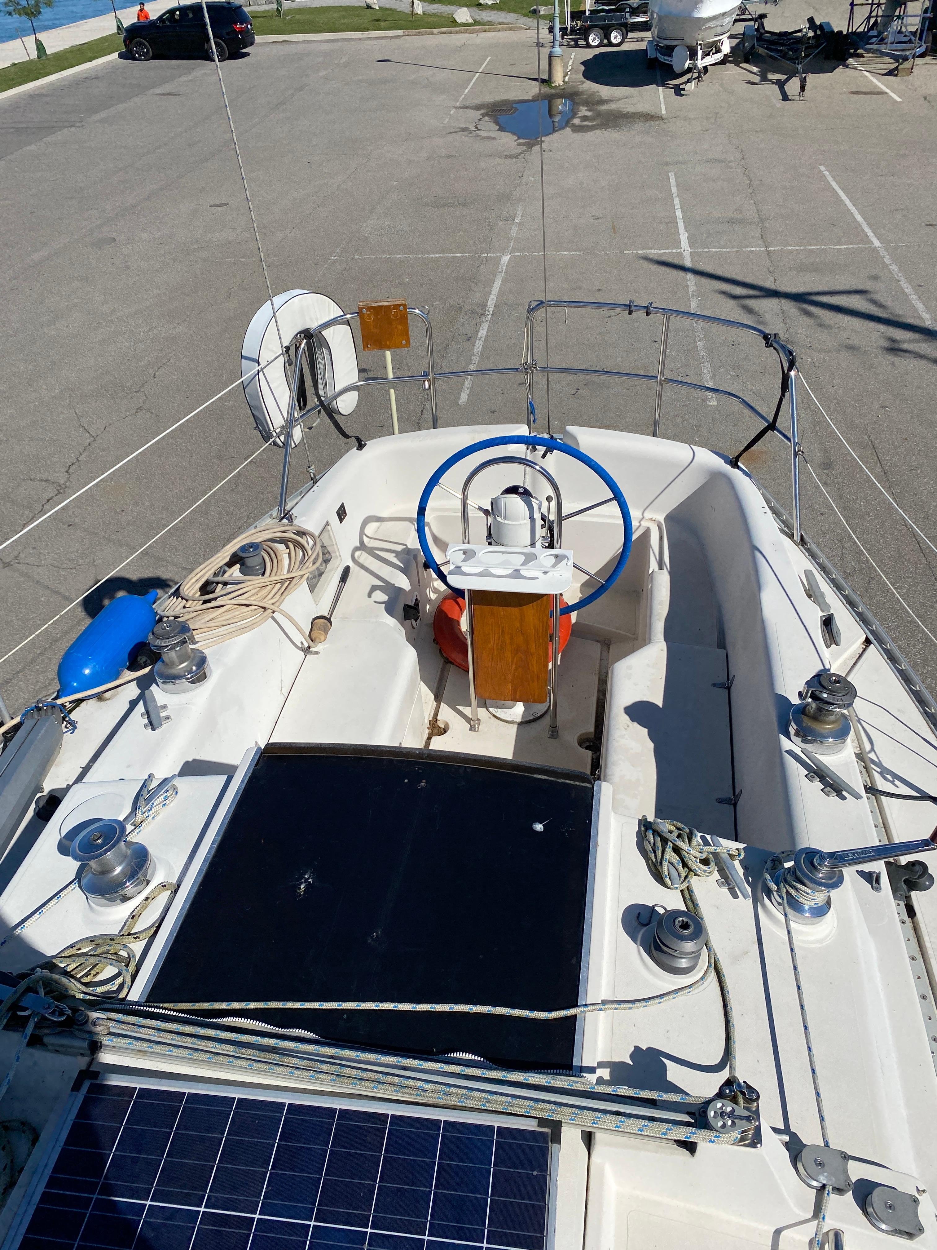 1985 CS 33 Sloop sailboat cockpit with blue steering wheel and deck equipment.