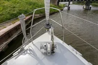 Bow of 2012 Puffin 30 Sloop, anchored near a canal bridge.
