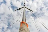 Mast of 2012 Puffin 30 Sloop against a cloudy sky, showcasing rigging and sail cover.