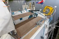 Cockpit of 2012 Puffin 30 Sloop with wooden deck, ropes, and safety equipment.