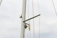 Mast and rigging of 2012 Puffin 30 Sloop with flag against cloudy sky.