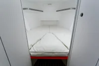 Interior cabin of 2012 Puffin 30 Sloop, featuring a cozy white bed.