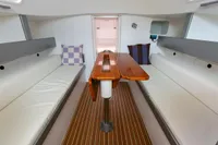 Interior of 2012 Puffin 30 Sloop, featuring cozy seating and wooden table.
