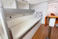 Interior of 2012 Puffin 30 Sloop, featuring a cozy seating area with a checkered pillow.