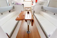 Interior of 2012 Puffin 30 Sloop, featuring wooden table and white seating.