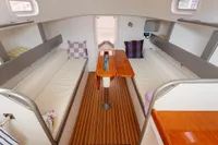 Interior of 2012 Puffin 30 Sloop, featuring cozy seating and wooden table.