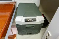 Portable cooler inside 2012 Puffin 30 Sloop, placed on wooden surface.
