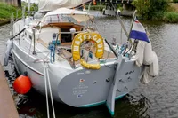 Sailing yacht Puffin 30 (9M) Sloop, 2012 model, docked with lifebuoy and flag.